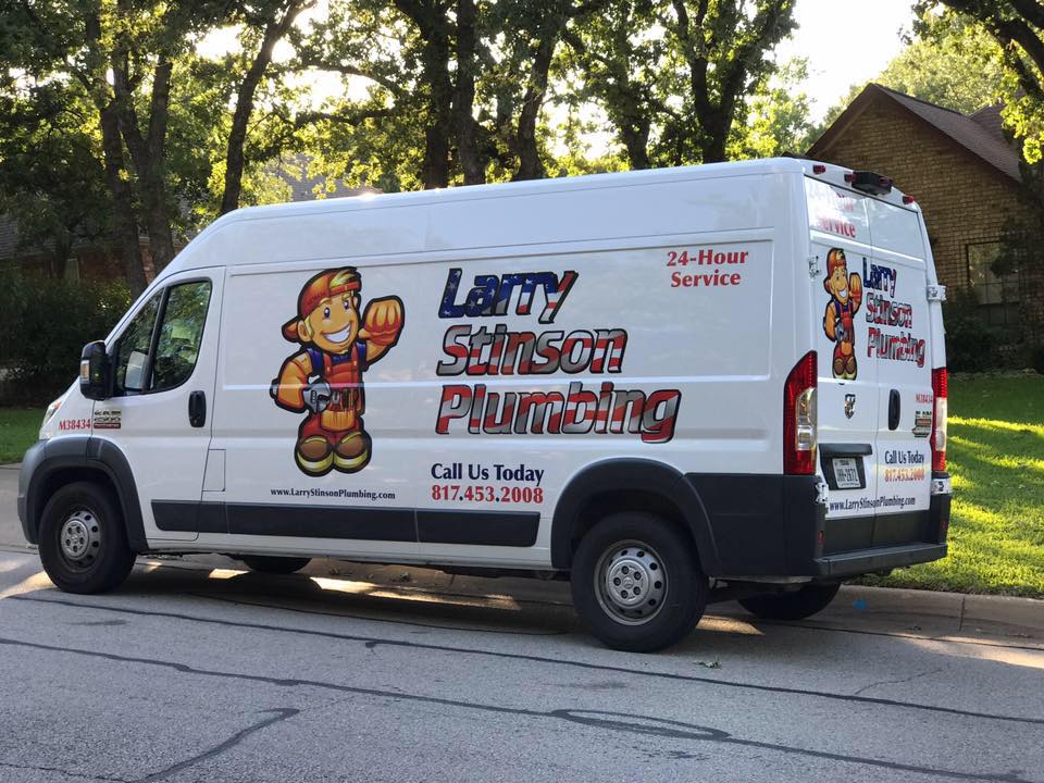 White plumbing service van parked on street.