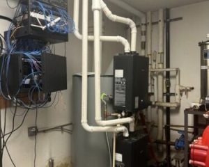 Industrial water heater with connected pipes and wiring.