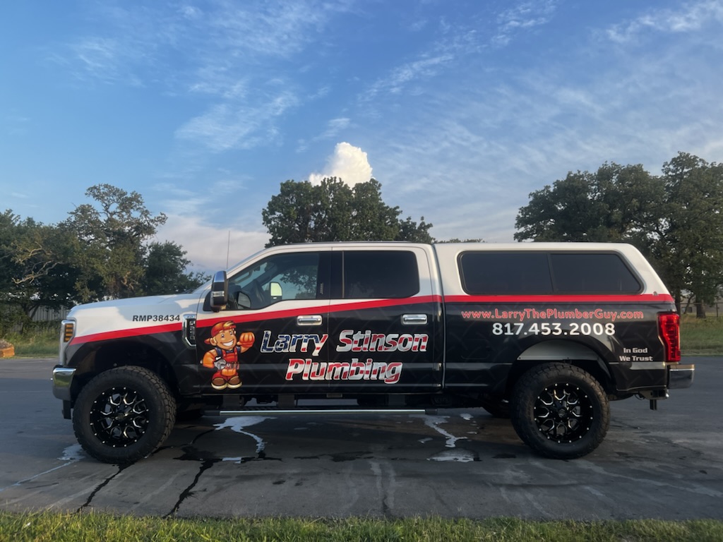 Plumbing truck with contact details on side.