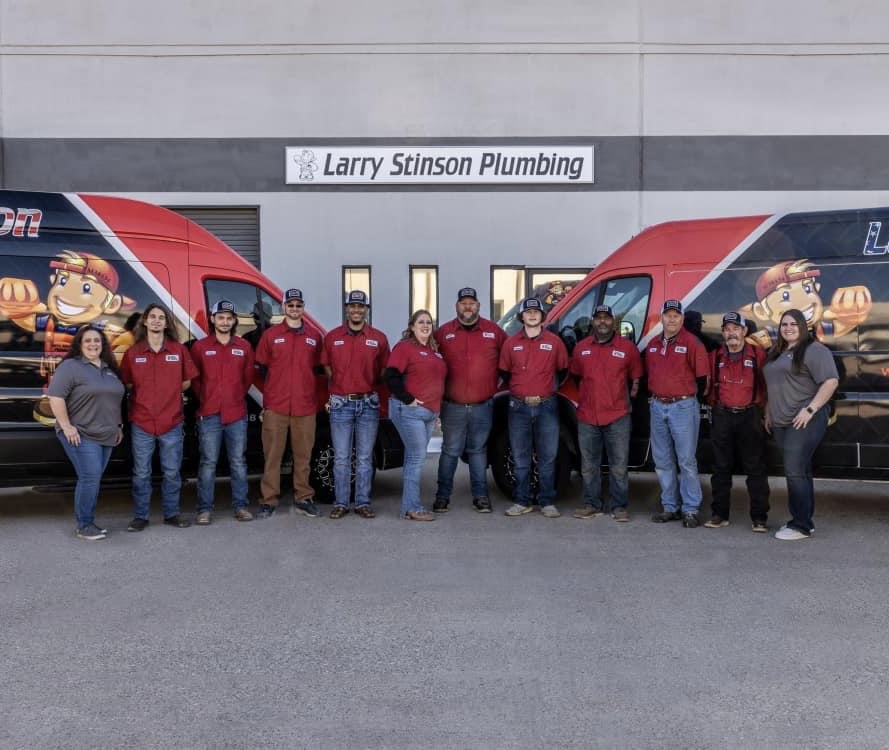 Larry Stinson Plumbing team standing outside company vans.