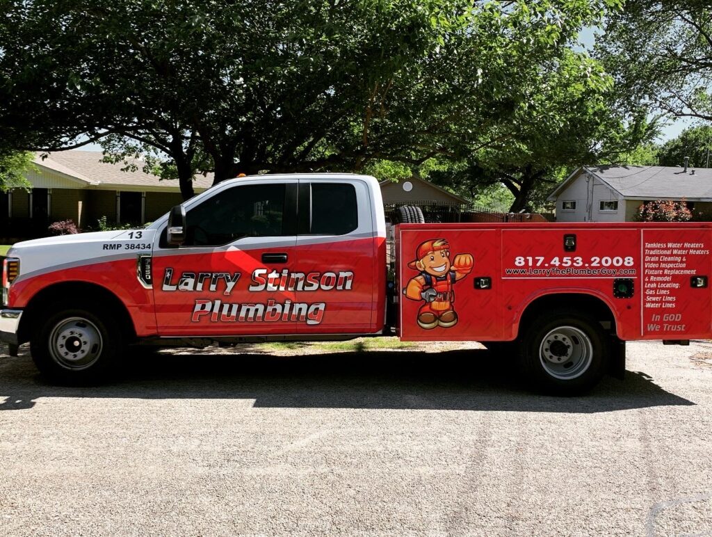 Red Larry Stinson Plumbing truck parked on street.