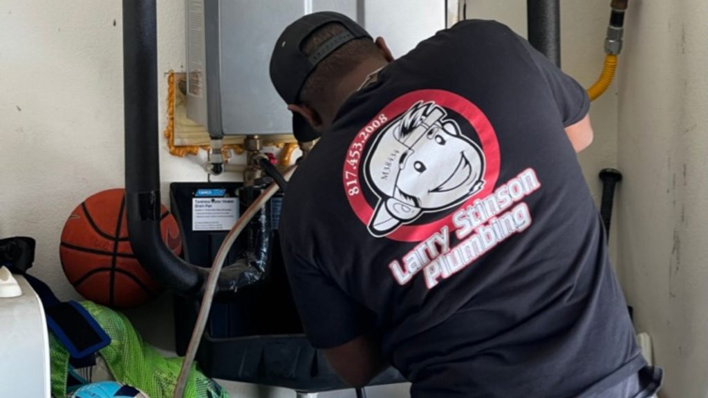 Plumber working on water heater installation.