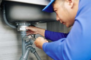 plumber fixing a garbage disposal